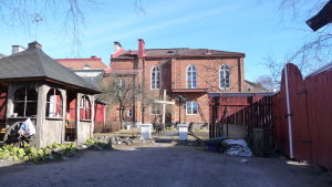 En del av loppisgården och kyrkans bakgård. betesdakyrkan i Ekenäs sett från bakgården, en röd tegelbyggnad i två våningar