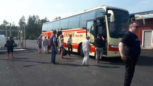 Passagerare stiger på bussen vid Ådön i Jakobstad. Passagerarna som var med på M/s Mässkär när den sjänk utanför Ådön stiger ombord på bussen.