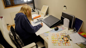 På fritiden tycker Daniela om att rita och sjunga men hon satsar också mycket på skolan och läxor. en flicka sitter och gör läxorna vid sitt skrivbord