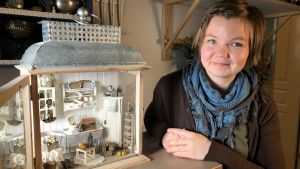 Salla Heikkilä med en lykta som är inredd med miniatyrmöbler