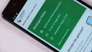 Mobiltelefon med den tyska corona-appen på skärmen