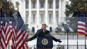 Expresidenten Donald Trump åtalades för att ha burit huvudansvaret för attacken, men friades. Donald Trump puhujakorokkeella Valkoinen talo taustallaan