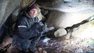 Grottan i Storberget i Vestervik i Ekenäs är en ganska typisk grotta bildad av stenar. Man kan inte riktigt stå där, det är drygt en meter till taket och ganska mörkt inne i den. En man inne i en liten grotta inne i ett berg. Takhöjd cirka en meter.