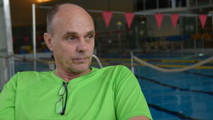 Hallmästaren Jouko Lupala sköter det tekniska i simhallen. Jouko Lupala iklädd en neongrön t-skjorta.