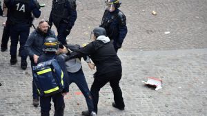 Det är incidenten på bilden som skakar president Emmanuel Macrons tillvaro i sina grundvalar. Frågan lyder: Varför är mannen, som antas vara Alexandre Benalla, på paraden och slår människor iklädd kravallhjälm? En man som misstänks vara Alexandre Benalla är våldsam på första maj.