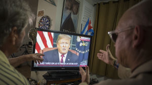 Miguel Saavedra och hans vän Oswaldo Hernandez ser på Trumps TV-tal hemma i Miami, Florida. Två personer ses titta på Donald Trumps tal i en TV.