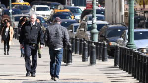 Den vita amerikanska mannens förlorade status anses vara en riksfaktor. Fotgängare går förbi säkerhetsstolpar i New York