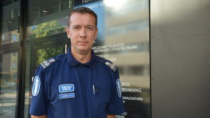 Stephan Sundqvist. Polisen Stephan Sundqvist står framför en mörk vägg och ser in i kameran.