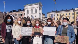 Ett gäng tonårsflickor demonstrerar mot rasism. De bär ansiktsskydd och har plakat i händerna.