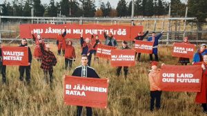 För samerna kan en äng vara renarnas betesmarker och lika med levebrödet, som här i fotograf Jonne Sippolas bild. Samers med protestplakat