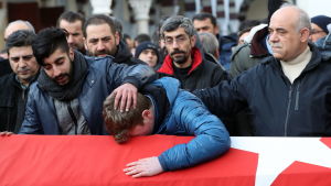 Familj och vänner sörjer Ayhan Arik som var en av de 39 människor som dog i attacken mot nattklubben Reina i Istanbul. En man särjer böjd över en kista andra män tröstar honom.