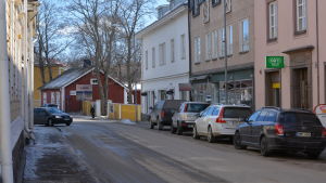 Då man står vid hörnet av torget ser man museigården och nybygget ska skymta fram. En gata med hus.