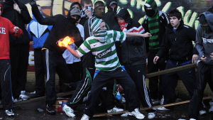 En ung man kastar en molotov cocktail under upplopp under paradsäsongen i Nordirland.