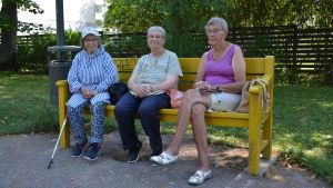 Leila Degerman, Alice Pitkänen och Marianne Abrahamson gillar träbänkarna i Runebergsparken. Tre damer på parkbänk.