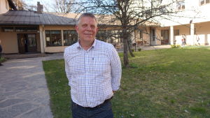 Professor Alf Norkko uppmanar oss alla att konsumera mindre. man på lummig innergård