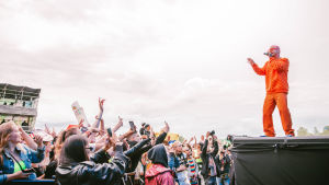 Yleisö seurasi J Balvinin keikkaa innolla puhelimen kamerat ojossa. Myös J Balvin itse kuvasi materiaalia keikaltaan omaan someensa. Yleisöä ja oranssiin pukeutunut J Balvin Ruisrockin lavalla.