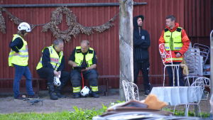 Räddningsverket får beröm för sin insats. Räddningsverkspersonal vid en husvägg.