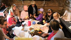 Trängseln hindrade inte verkstadsdeltagarna från att pyssla. Barn och mammor som pysslar runt ett bord.