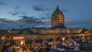 Kazankatedralen i S:t Petersburg. Folk äter middag på en takterass framför Kazankatedralen.