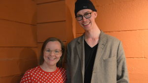 Lotta Elo och Olli Sirén hade hoppats på mer diskussion. En kvinna och en man står vid en rödmålad vägg och ler.