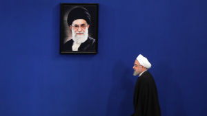 Irans president Hassan Rouhani går förbi ett foto på den högsta ledaren Ali Khamenei