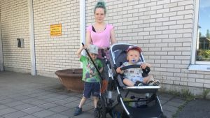 Jenny Sandström och hennes barn Jami och Jeri fick höra om lunchen idag. En kvinna med sin ena son i en barnvagn och den andra bredvid sig.