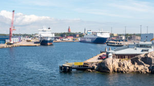 Hangö hamn har värpt många guldägg åt staden, men stadsdirektören säger att staden inte får förlita sig på att den alltid delar med sig av vinsten för att lappa på stadens budget. Hangö hamn. Sommar. Några blå-vita Finnlines båtar i hamn. Bilden är tagen från havet mot land. I bakgrunden kan man skymta Hangös vattentorn.