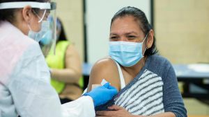 Distributionen av coronavaccin har börjat knaggligt i USA. Bidens utmaning blir att få fart på vaccindistributionen. Kvinna i USA vaccineras mot Covid-19.
