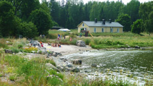 Badstranden och hamnområdena ska utvidgas. Så här såg det ut på Fagerö sommaren 2010. badstrand och gult hus på sommaren