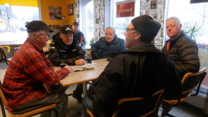Kommunalpolitikexperterna i Nykarleby samlas på kaffebaren Ett sällskap äldre män runt ett cafébord.