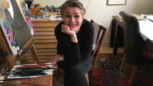 Riikka Juvonen sitter vid sitt staffli hemma i studion i Berghäll. Riikka Juvonen sitter vid sitt staffli.