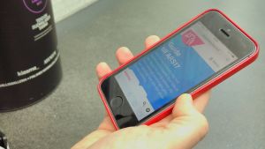 Mobilguide till ARS17-utställningen. En hand som håller i en telefon där ARS17-mobilguiden syns på displayen.