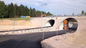 I Svedja i Karis har korsningar plockats bort och istället kör man i tunnel. En nybyggd järnvägsundergång för bilar och lätt trafik i Svedja i Karis. Också män i arbetskläder syns på bilden.