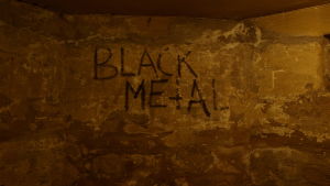 Graffiti på väggen i skivbutiken Helvetes källare. Texten "Black Metal" som graffitti på en vägg i en källare