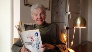 Märta Tikkanens författarskap spänner över fem decennier. Märta Tikkanen sitter med boken Århundradets kärlekssaga i famnen
