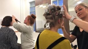 Ida-Maria Andersson och Emmy Wikström sminkas och får sitt hår fixat. Luciakandidaterna sminkas inför De tios dag.