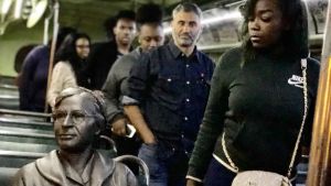 Rosa Parks banade väg för de svartas rätt att sitta i bussen. Figuren som föreställer Rosa Parks sitter i bussen på en vit plats. Nyfiken publik passerar