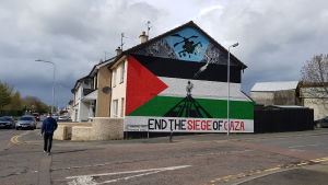 En man går förbi en pro-palestinsk väggmålning i nordirländska Strabane.