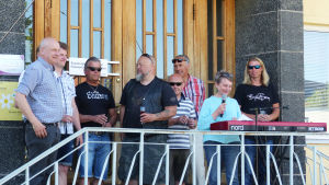 Kaj Björklöf, Tommi Peltonen (står bakom Björklöf), Kim Vidfält, Bo Vidfält, Kenneth Jäkälä, Karl-Johan Hellman, Roger Lönnberg, Karin Svahnström och Henrik Lillqvist är kärntruppen i talkogänget. En bild på glada människor i centrum av Karis. De står på en trappa och en av personerna håller tal.
