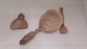 Skedar av horn och ben på Finlands nationalmuseum. Närbild på tre stycken skedar av horn och ben i en vitrin.