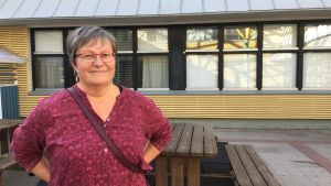 Lena Ahlroth är klasslärare och jobbar aktivt med miljöfrågor i skolvardagen. En kvinna står på en skolas innergård.