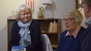 Marianne Isaksson-Heimberg och Kristina Dufholm framför en bokhylla med 1950-talsprylar. Marianne Isaksson-Heimberg och Kristina Dufholm.