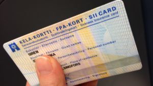 Du ska ha med dig FPA-kortet när du åker taxi som FPA ersätter. Ett FPA-kort med namn och andra uppgifter. En hand håller i kortet.