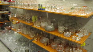 Många tycker om att fynda glasvaror på loppis. Hylla med olika sorters glasvaror.