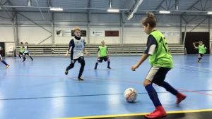 Sisus juniorer under pågående träningspass. En pojke har bollen under kontroll medan en annan försöker täcka.