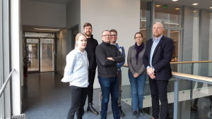 Hållbara kemister, Tiina Saloranta-Simell, Wolter Rautelin, Jan-Erik Lönnqvist, Patrik Eklund, Matilda Kråkström och Reko Leino. 6 människor, 2 kvinnor och 4 män står i korridor mot räcke