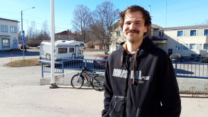 Christian Hansson En man i 30-årsåldern står på en gård. Han har medellångt mörkt hår och en tjock mustasch.