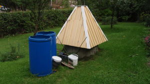 Symbolbild. Brunnen på bilden har ingenting med brunnen i min berättelse att göra En trädgårdsbrunn med tak.