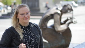 Pamela Andersson, före detta utställningskurator på Kuntsi, har sedan 2015 varit involverad i boken om Bröderna Gröndahls stiftelse som en av redaktörerna. Här står hon framför skulpturen "Djup törst" av Erkki Kannosto. Vit kvinna med långt blont hår står framför en skulptur av Erikki Kannosto.