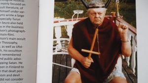 Pekka Siitoin allvarlig äldre man med ockulta symboler i händer och på huvud